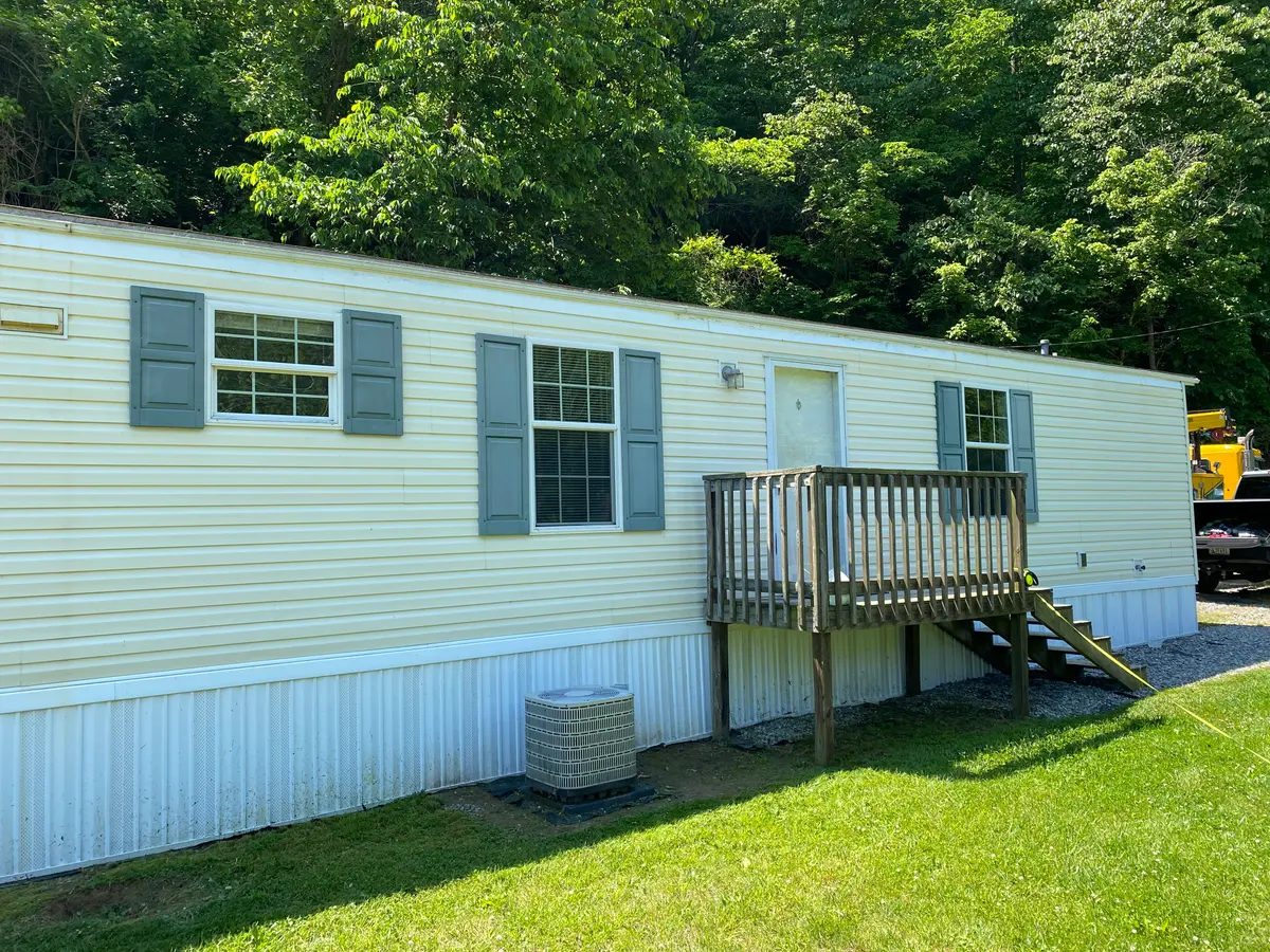 The same mobile home exterior after pressure washing